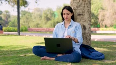 Indian girl relaxing after work in a park