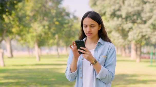 印度女孩白天在公园里用手机 — 图库视频影像