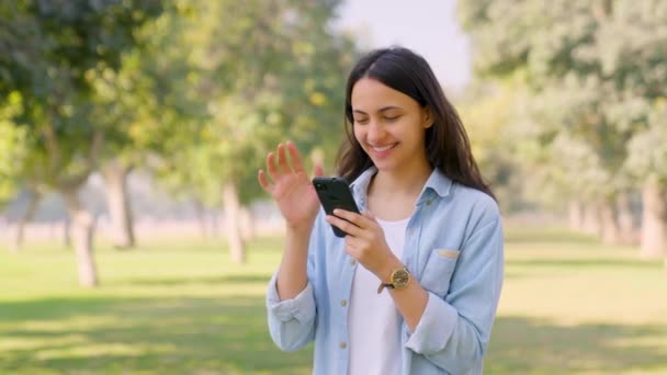 Счастливая Индийская Девочка Пользуется Мобильным Телефоном Парке Улыбается — стоковое видео