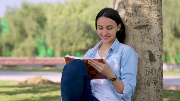 Щаслива Індійська Дівчинка Читає Книжку Парку Вдень — стокове відео
