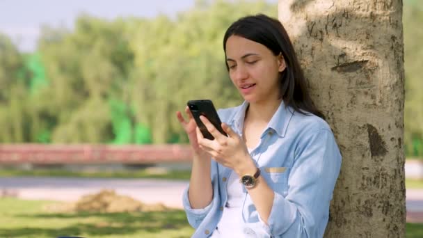 Indian Girl Scrolling Phone Park Daylight — Stockvideo