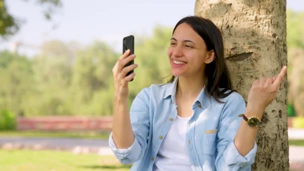 快乐的印度女孩在公园里打电话给某人 — 图库视频影像