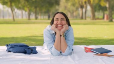 Happy Indian girl lying down in a park