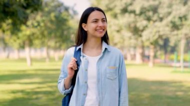 Indian college exploring smiling to the camera in a park in daylight