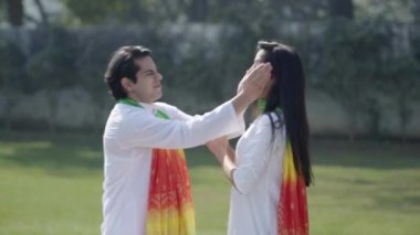 Indian couple enjoying Holi in a park