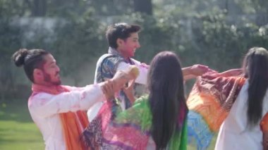 Indian couples playing Holi in a park