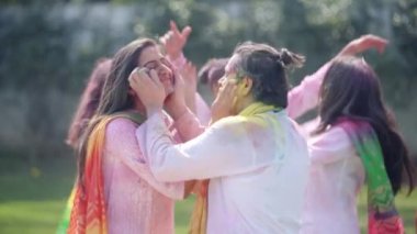 Indian couple putting colors at each other faces on Holi