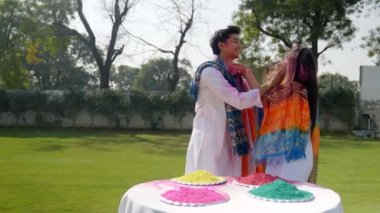 Friends playing Holi in a park