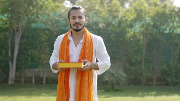 Cute Indian Man Offering Sweet Box Camera — Vídeos de Stock