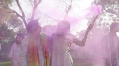 Romantic Indian couple with a smoke powder candle in a Holi party