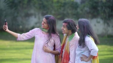 Indian friends clicking pictures in a Holi festival