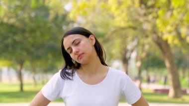 Indian woman doing neck stretching in a park in morning