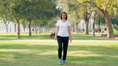 Indian woman doing leg stretch in a park in morning
