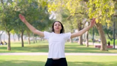 Indian girl doing jumping jacks in a park in morning