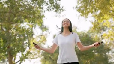 Woman gets tired and exhausted after skipping rope in a park in morning