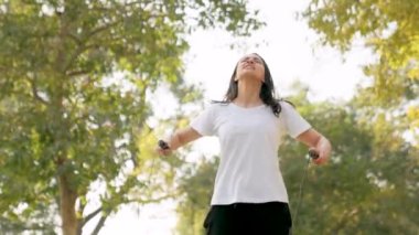 Indian woman gets tired after skipping rope in a park in morning