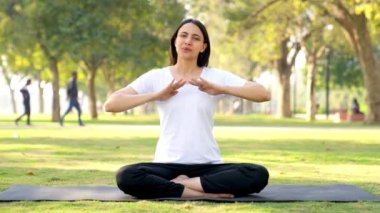 Indian girl doing breathe in breathe out exercise in a park in morning