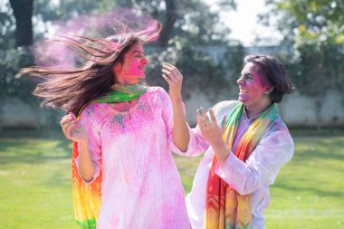 Beautiful Indian couple playing Holi with colors