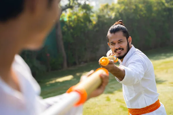 Indian men playing Holi with water gun