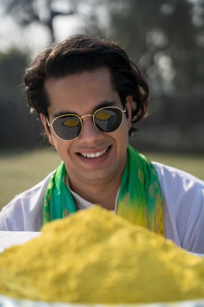 Cool Indian man looking at colors in a Holi festival