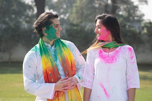 Cute Indian couple looking at each other in Holi party