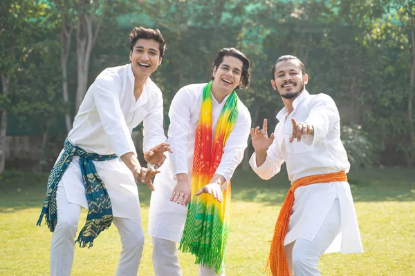 Indian men dancing at a Holi festival in traditional wear