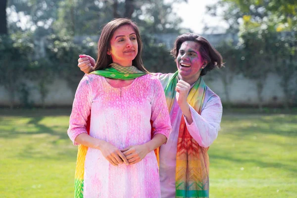 Indian man surprises his wife from back at a Holi party