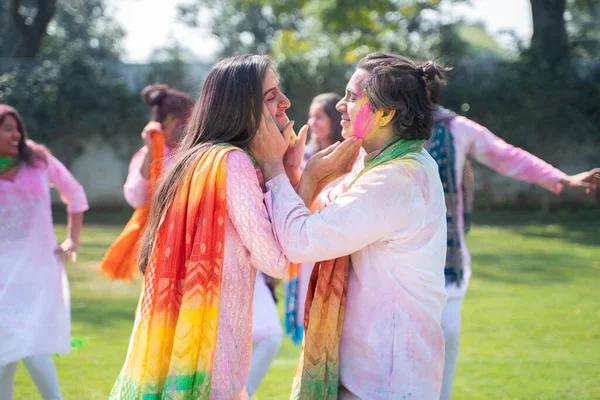 Indian couple putting colors at each other faces on Holi