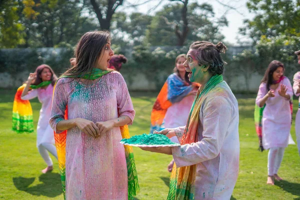 Happy and shocked Indian girl at a Holi party