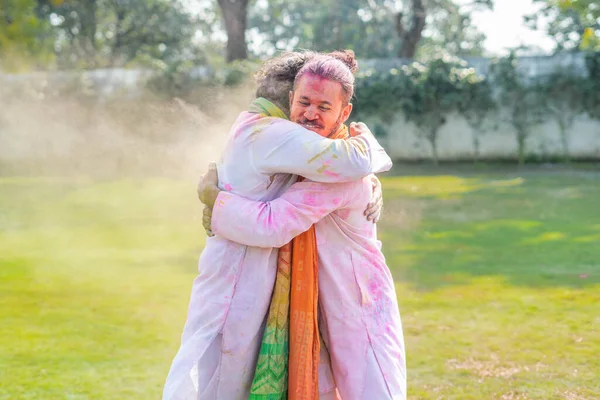 Indian friends hugging in a Holi party