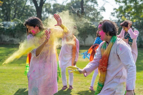 Indian man throwing color at his wife face at a holi party
