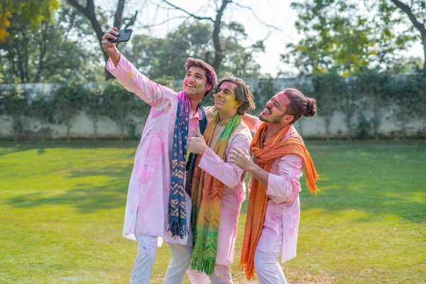 Indian men clicking selfies at Holi party