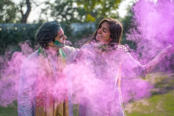 Indian couple with smoke color at a Holi party
