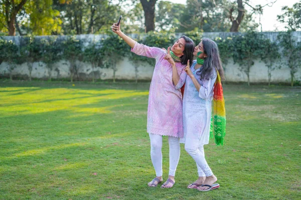 Indian girl clicking selfies at a Holi party