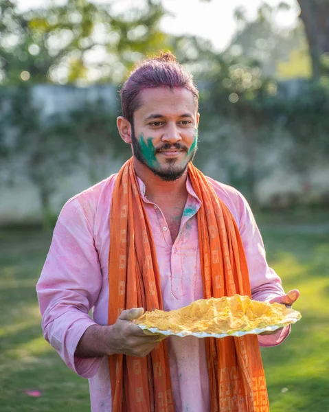 Indian man with a plate of Gulal color in holi