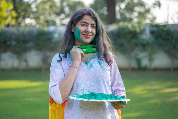 Indian woman with a plate of Gulal color in holi