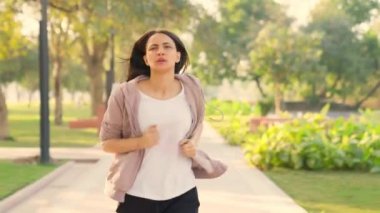 Young Indian girl gets tired after running in a park in morning time