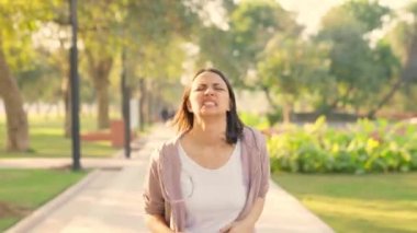 Indian young woman exhausted after running in a park in morning time