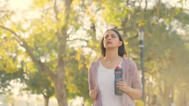朝の公園で水筒を持って走る女 — ストック動画