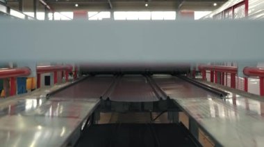 Modern metal fabrikasında metal ya da çelik levha oluşturma makinesi. Çatı Üretim Süreci. Ekipmanların çalışması yavaş çekimde gösterilir