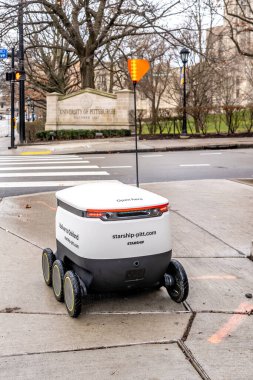 11 Ocak 2020 'de Pittsburgh, PA, ABD' deki Pittsburgh Üniversitesi 'nin kaldırımında bir Starship yiyecek dağıtım robotu sürüyor. Robotlar dört kampüs restoranından yemek getiriyor..