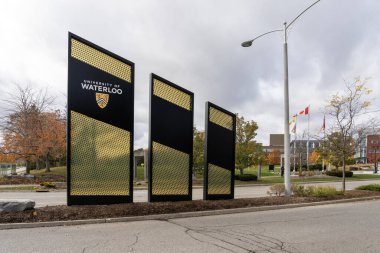 Waterloo, On, Canada - October 17, 2020: University of Waterloo (UW) pylon sign is seen at the main campus entrance in Waterloo, On, Canada. UW is a Canadian public university. clipart