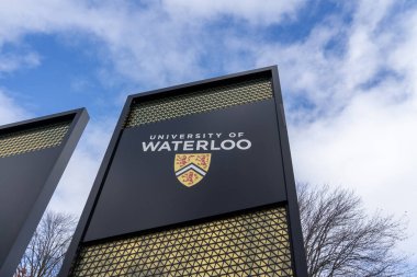 Waterloo, On, Canada - October 17, 2020: University of Waterloo (UW) pylon sign is seen at the main campus entrance in Waterloo, On, Canada. UW is a Canadian public university. clipart