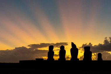 Şili 'deki Paskalya Adası' ndaki (Rapa Nui) Tahai kompleksindeki Ahu Vai Ure 'deki moai heykellerinin arkasında gün batımı. Tahai, Hanga Roa köyü yakınlarındaki üç tören platformundan oluşan bir arkeolojik kompleks..