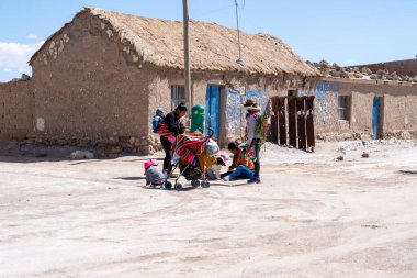 20 Şubat 2023 'te Uyuni, Bolivya' daki tren mezarlığındaki yerel kadın ve çocuklar. Uyuni, Güney Amerika 'nın Bolivya eyaletinde yer alan bir şehirdir..