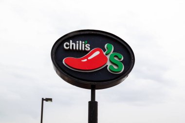 Lansing, Michigan, ABD - 30 Mart 2022: Arka planda gökyüzü olan Chili 'nin kutup tabelasının kapatılması. Chili 's Grill and Bar, Amerika' da sıradan bir restoran zinciri. Sadece editör kullanımı.