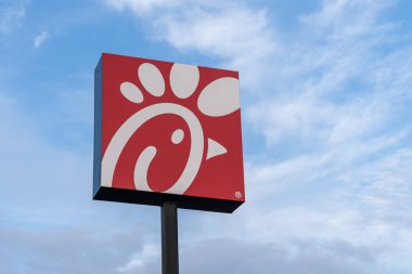 New Orleans, Louisiana, ABD 12 Şubat 2022 'de arka planda mavi gökyüzü olan bir Chick-fil-A logo tabelası. Chick-fil-A, Amerika 'nın en büyük fast food restoran zincirlerinden biridir..
