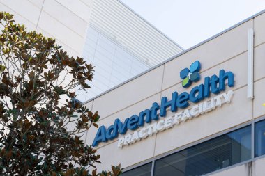 Orlando, Florida, ABD - 20 Ocak 2022: Orlando, Florida, ABD şehir merkezindeki binada AdventHealth Practice Facility 'nin işareti. AdventHealth inanç temelli, kar amacı gütmeyen bir sağlık sistemidir..