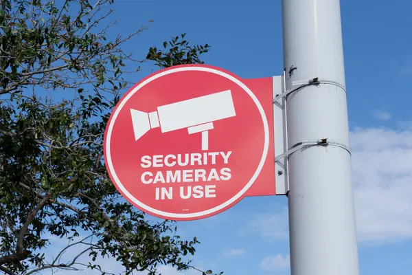 Czerwone Kamery Bezpieczeństwa Użyciu Znak Słupie Światła Drzewem Błękitnym Niebem — Zdjęcie stockowe