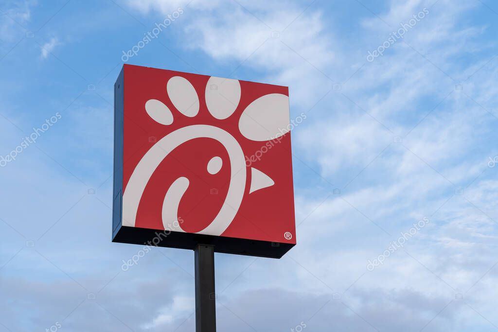 New Orleans, Louisiana, USA- February 12, 2022: A Chick-fil-A logo pole sign with blue sky in background. Chick-fil-A is one of the largest American fast food restaurant chains.